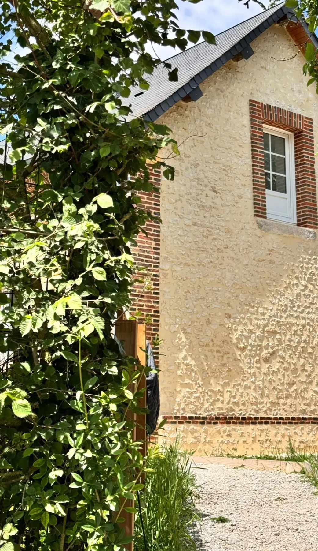 Façade de maison en pierre avec encadrements en brique